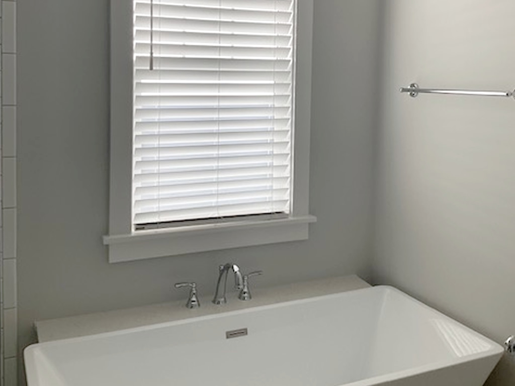 Faux Wood blinds installed in a bathroom behind a tub