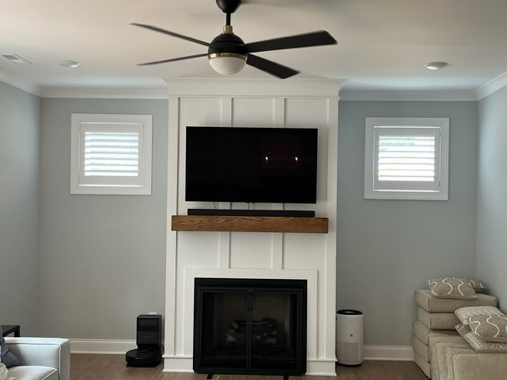 Small shutters installed on a wall in a living room at either side of a fireplace