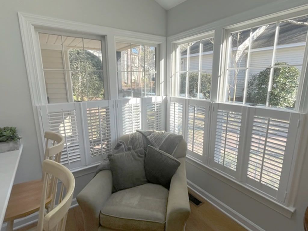 A set of 4 shutters installed in the corner of a sun-room in North Carolina wiht a view of the yard