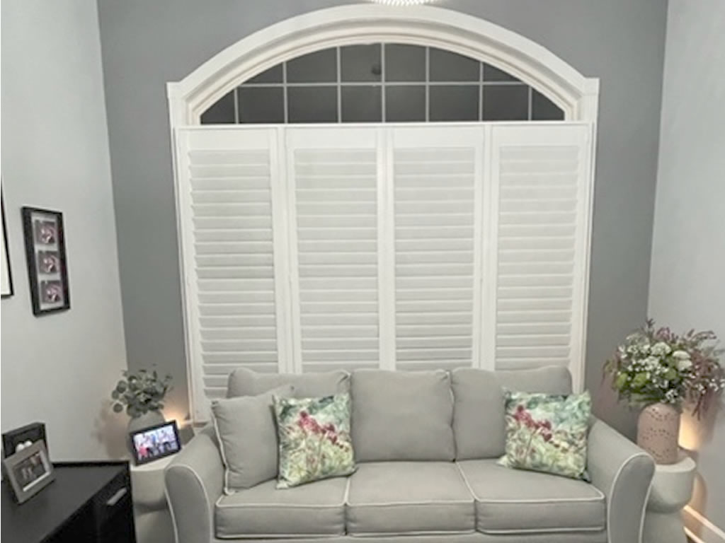 Shutters installed by Prestigious Window Fashions with a couch in front