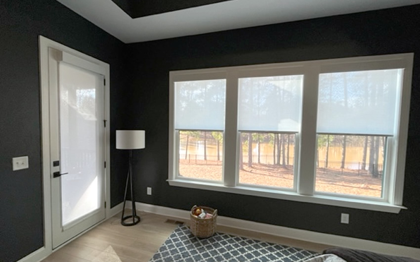 Sheer shades on a door and windows installed in a living room