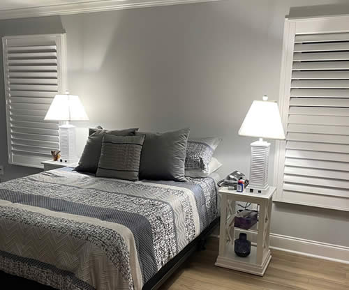 Shutters in two windows cleanly installed in a bedroom